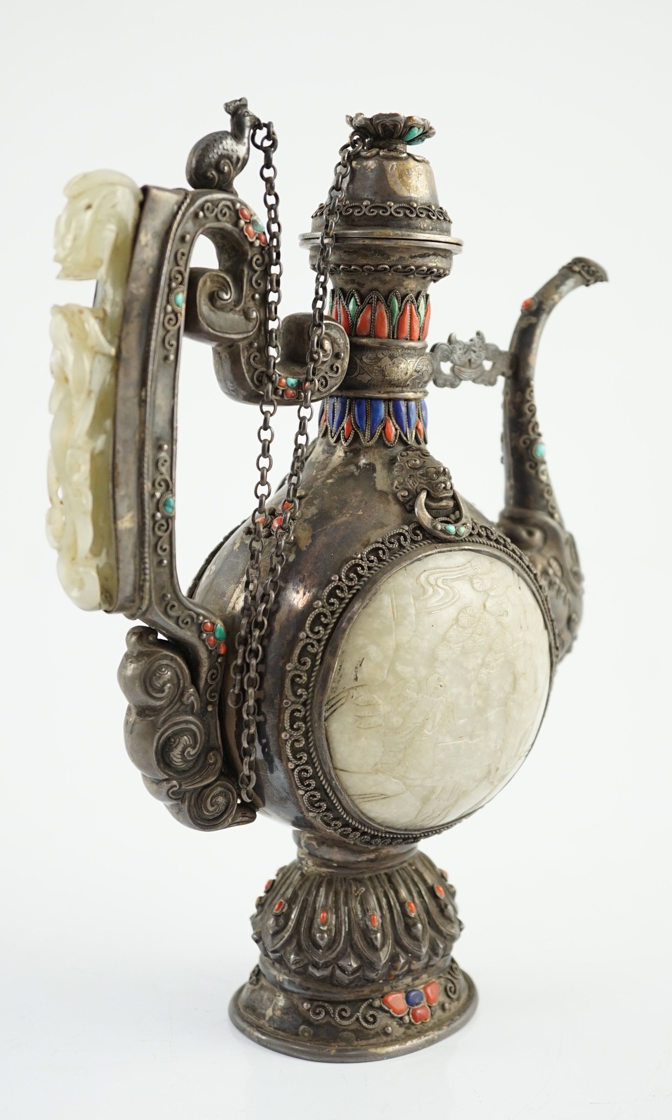 A Tibetan silver, jade, coral and hardstone mounted ewer, late 19th century, the Chinese pale celadon jades, 18th/19th century finial lacking stones